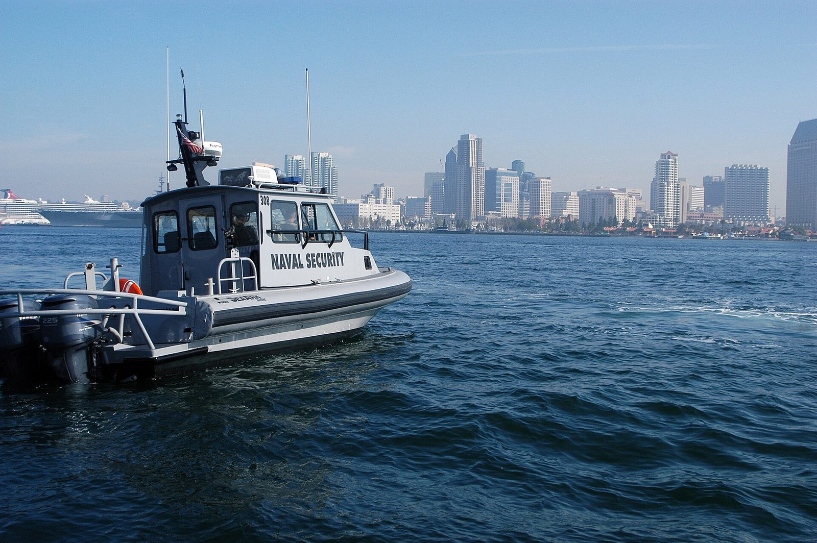 A Navy harbor security boat on San Diego Bay, with downtown behind it. The bay is a working military harbor, not just a view.