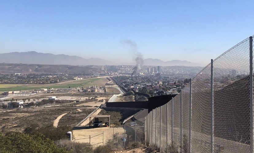 Layers of fence and wall at the border, with Tijuana beyond. The planned Otay Mesa East port of entry would give the region a third major crossing.