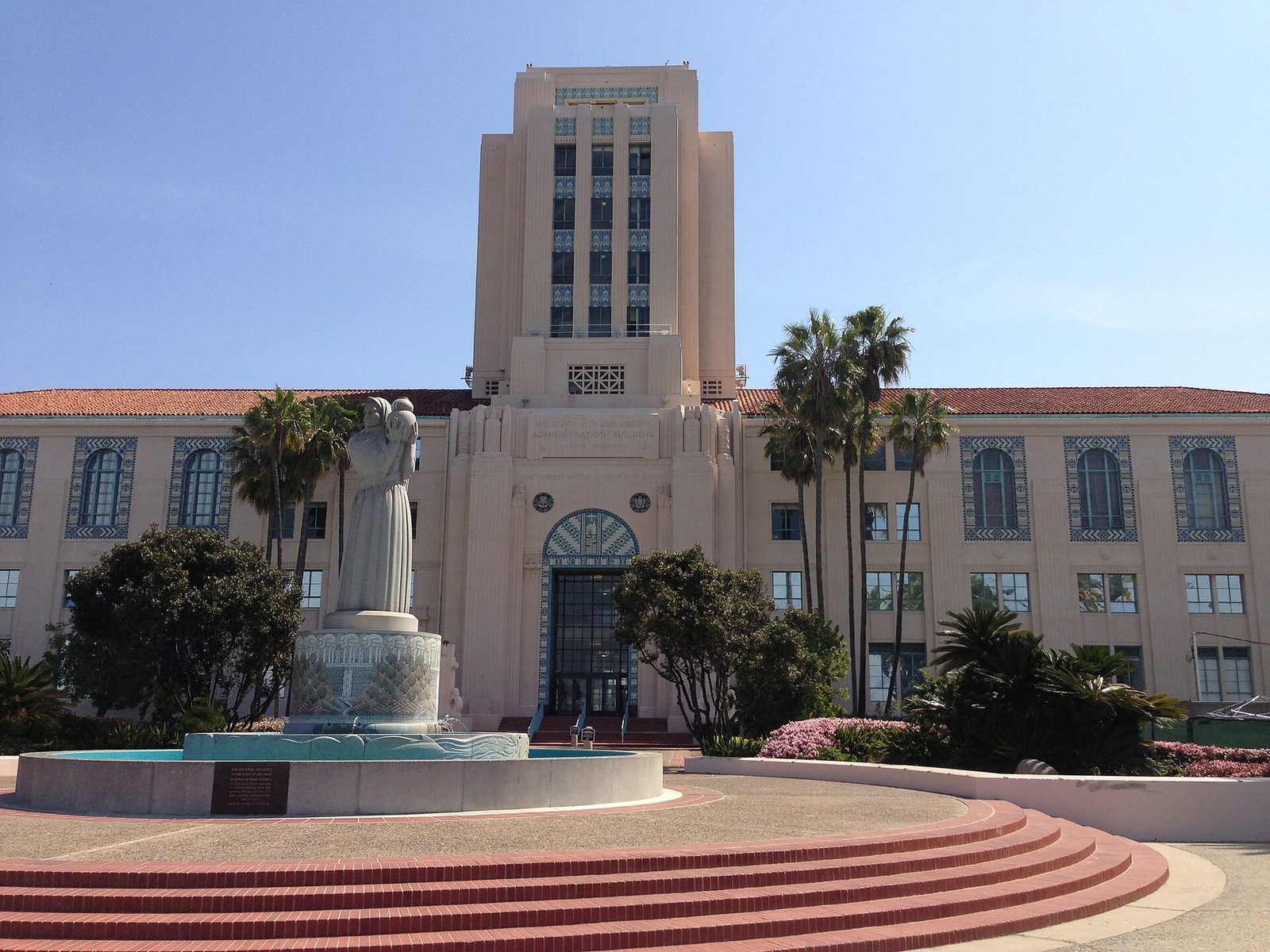 The San Diego City and County Administration Building on Pacific Highway, the Guardian of Water fountain in front. The words carved over its door read that the noblest motive is the public good.