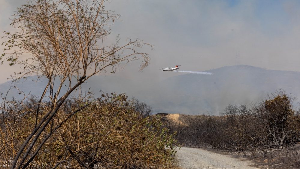An air tanker makes a drop over burned ground at Camp Pendleton on Friday, October 16. Air and ground units from Cal Fire and other agencies have supported the Camp Pendleton Fire Department since Thursday.