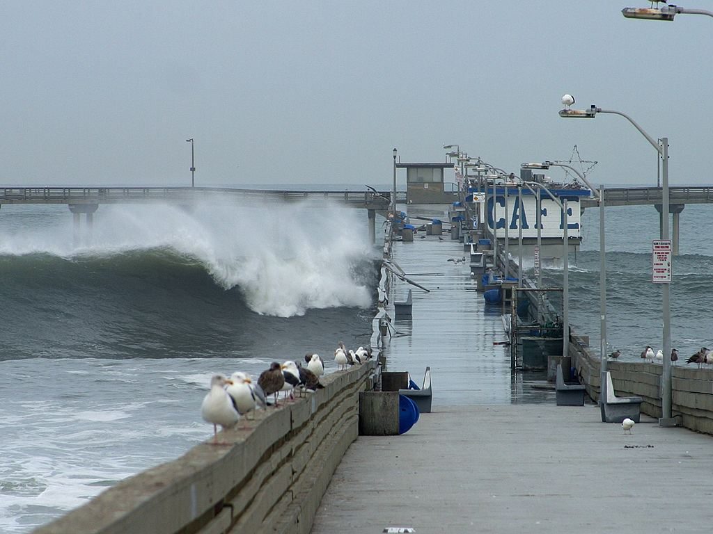 A wave breaks beside the Ocean Beach pier, Dec. 21, 2002. The Weather Service has high confidence in significant coastal flooding and beach erosion across San Diego County beaches on Sunday.